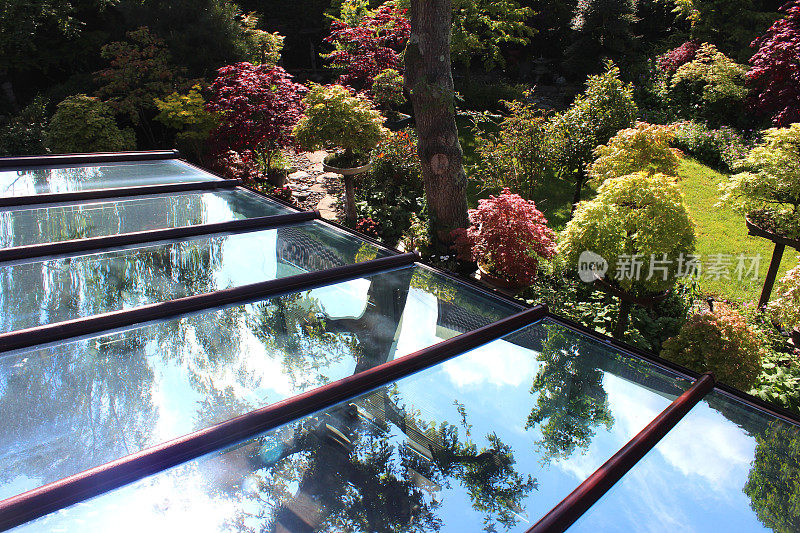 玻璃温室屋顶面板/窗格的图像，反映了蓝天